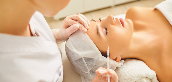 Mujer en un centro de estética recibiendo un tratamiento. Prevención de riesgos laborales en un centro de estética.