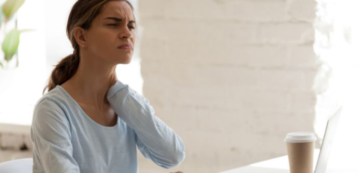 Riesgos del sedentarismo laboral. Chica con dolor de cuello.